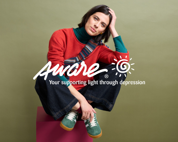 A group of men and women smiling holding Aware charity logo