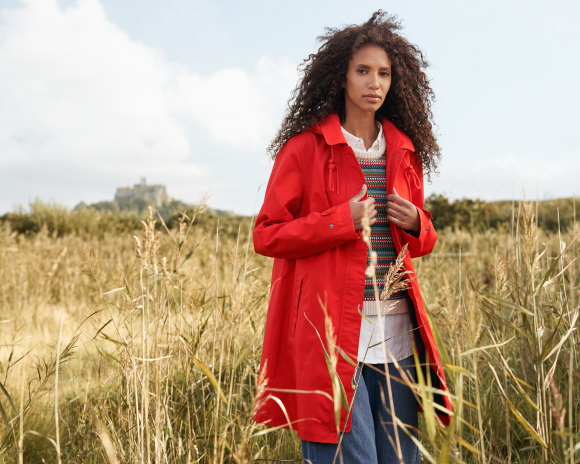 Woman in red coat stood in field