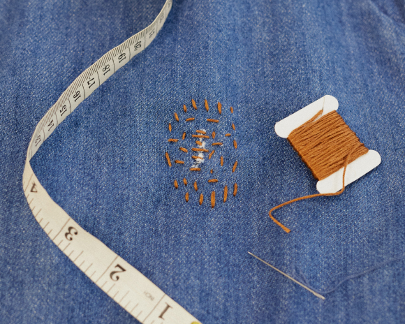 Visible mending on denim