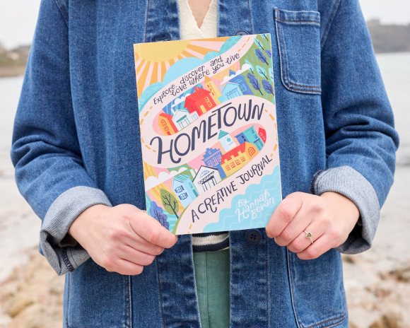 A person holding a copy of Hometown Journal